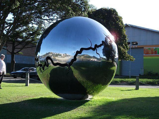Large shiny sphere on the riverbank.